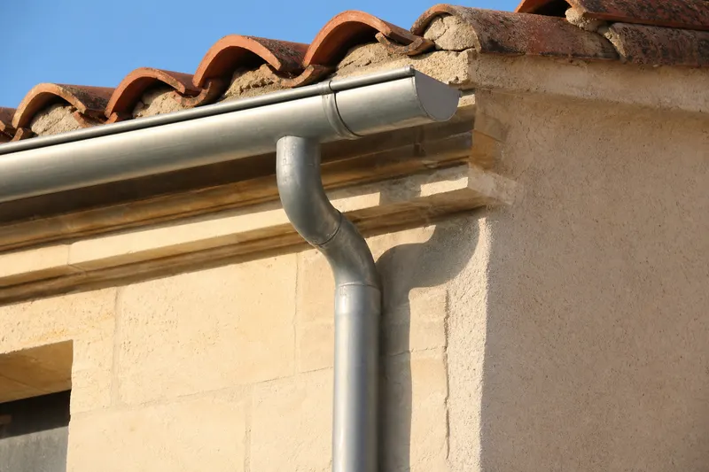 Gouttière zinc demi-ronde posée sur façade en pierre calcaire